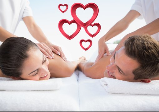 Masseur giving massage to couple at spa