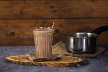 Hot Cocoa drink Chocolate milk in a glass on a wooden surface