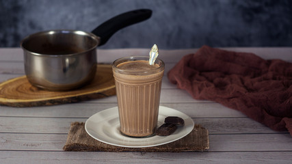 Hot Cocoa drink Chocolate milk in a glass on a wooden surface