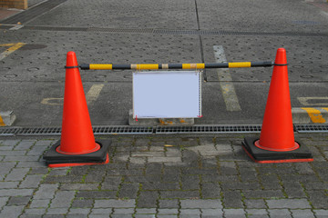 sign board with red cones on road
