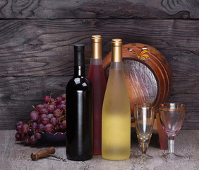 bottle of wine and wooden barrel for wine on a wooden table, still life, wine tavern