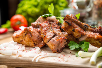 Assorted delicious grilled meat with vegetable on white plate  picnic table for family bbq party