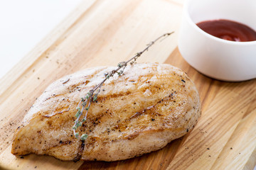 grilled chicken with sauce on a wooden board