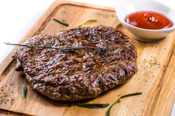 big steak on a wooden board with sauce