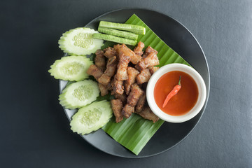 Pork Fried with vegetables eaten on black table.