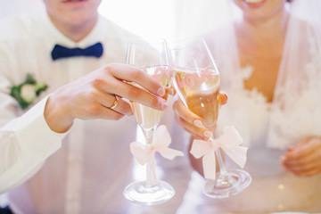 Bride and groom clang chmapagne flutes with pink letterings 'Lov