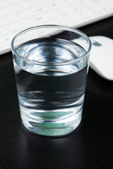 Transparent glass of water. On a dark table. For your design.