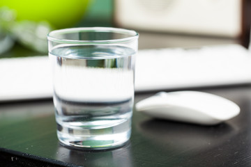 Transparent glass of water. On a dark table. For your design.