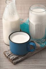 Glass, cup, bottle with kefir on a wooden stand