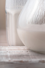 Glass and pitcher of kefir on the wooden stand