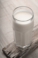 Glass kefir on a wooden stand on the table