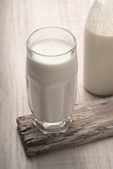 Glass with kefir and a bottle on a old stand