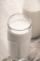 Glass with kefir and a bottle on a wooden stand