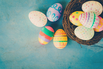 Colorful easter egg in the nest on blue pastel color wood backgr