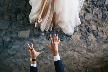 Look from above at groom's hands trying to catch bride
