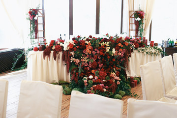 Look from afar at dinner table for newlyweds covered with carpet