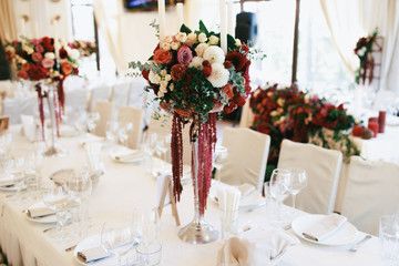 Silver candleholders with bouquets of red and white flowers stan