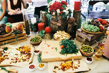 Table with snacks, fruits and cheese on large beige table