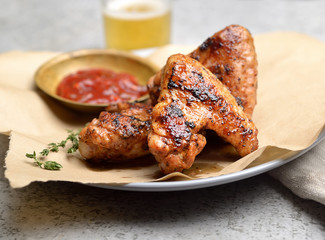 Delicious crispy chicken wings with sauce and beer