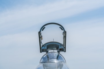 Hornet fighter jet reflects the sunshine - falcon cockpit under opened canopy at air show. Cockpit...