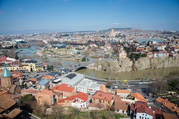 Fototapeta na wymiar TBILISI, GEORGIA - MARCH 5, 2016: Top view of the river and the Church in the central part of the city.