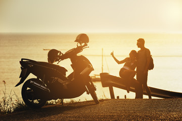 Happy couple sunset sea motorcycle road