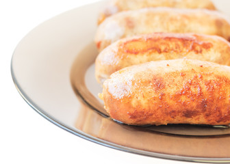 Homemade grilled sausages in a plate isolated on white background.
