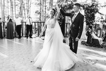 Groom whirls bride on porch before wedding altar