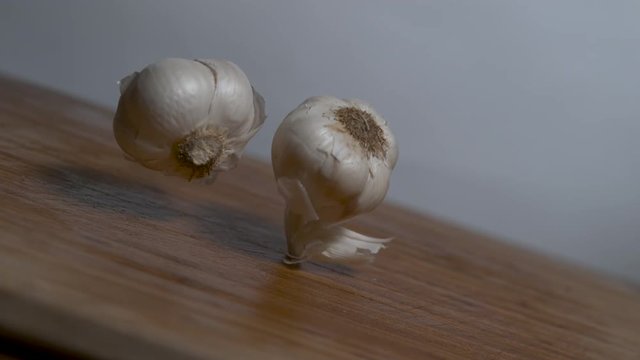 Perfect Cloves of garlic falling in slow motion onto a cutting board