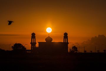 A silhouette of a mosque at sunrise vivid color , Thailand