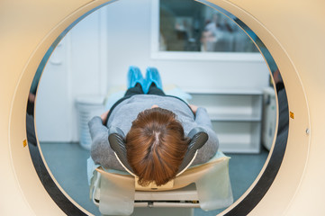 Close up patient at CT scan tomography in hospital, shot through the tube of device. Selective focus