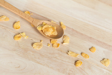 cereal cornflakes spilling out from the wood spoon