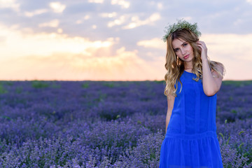 Beautiful Girl in lavender Field at sunset. Pretty woman Provence style in a dress and flowers wreath. Beautiful blonde woman in the lavender field on sunset Amazing portrait