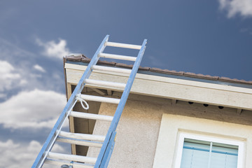 Aluminum Construction Ladder Leaning Against House.