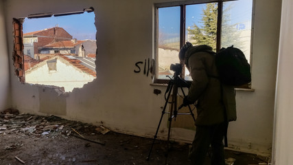 Photographer shooting in a ruined abandoned apartment