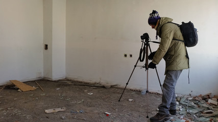 Photographer shooting in a ruined abandoned apartment