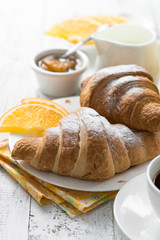 Croissant jam coffee orange jice at white wooden table. 