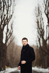 handsome and young man standing in the park alone