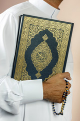 Close-up of a Muslim man holding Quran..