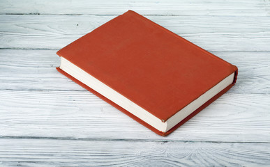 Blanc book cover on textured wooden background.