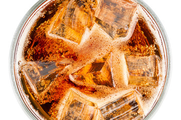 Glass with fizzy cola and ice cubes closeup
