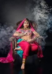 Indian Princess sitting in a chair against a background of a smoke