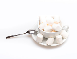 cup with marshmallow on plate with spoon