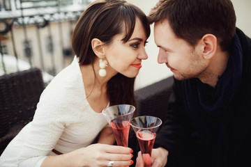 beautiful and young couple drinking champagne on terrace