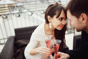 beautiful and young couple drinking champagne on terrace