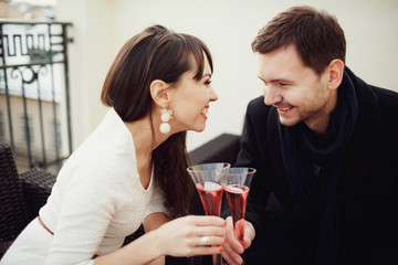 beautiful and young couple drinking champagne on terrace