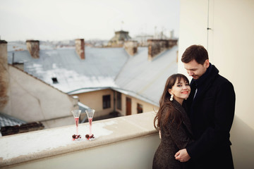 beautiful and young couple standing together on terrace