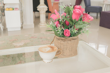 Beautiful bouquet of flowers in a coffee shop with coffee cup.