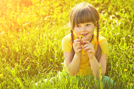 girl sitting in the grass with dandelion