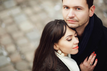 man and woman stands and hug each other outdoors